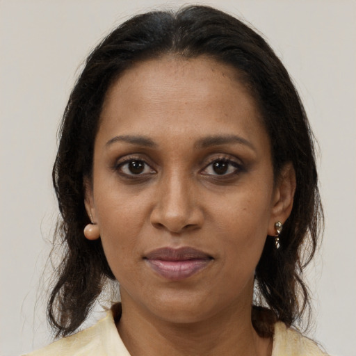 Joyful black adult female with medium  brown hair and brown eyes