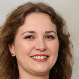 Joyful white adult female with long  brown hair and brown eyes