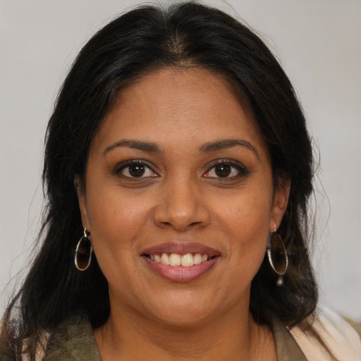 Joyful latino adult female with medium  brown hair and brown eyes