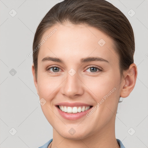 Joyful white young-adult female with short  brown hair and grey eyes