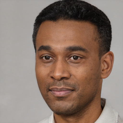 Joyful black young-adult male with short  black hair and brown eyes