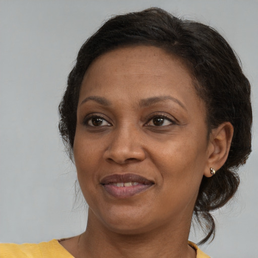 Joyful black adult female with medium  brown hair and brown eyes