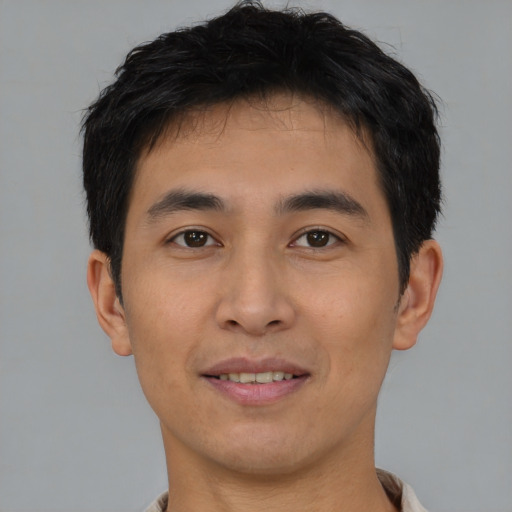 Joyful asian young-adult male with short  brown hair and brown eyes