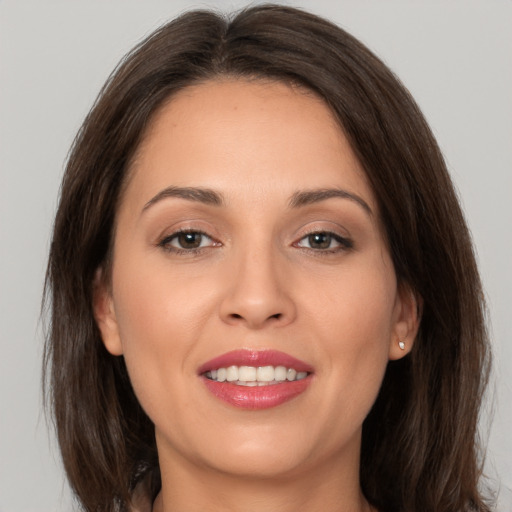 Joyful white young-adult female with long  brown hair and brown eyes