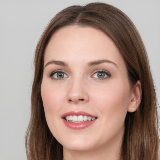 Joyful white young-adult female with long  brown hair and grey eyes