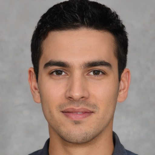Joyful white young-adult male with short  black hair and brown eyes