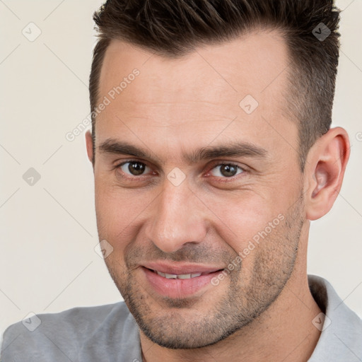 Joyful white adult male with short  brown hair and brown eyes