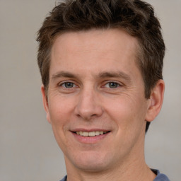 Joyful white adult male with short  brown hair and grey eyes