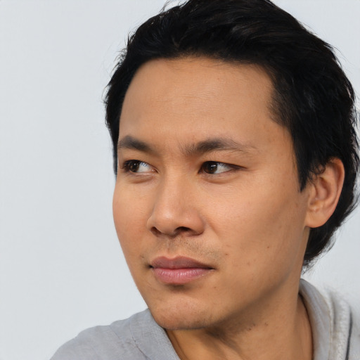 Joyful asian young-adult male with short  black hair and brown eyes