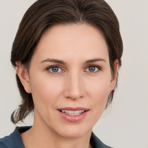 Joyful white young-adult female with medium  brown hair and grey eyes