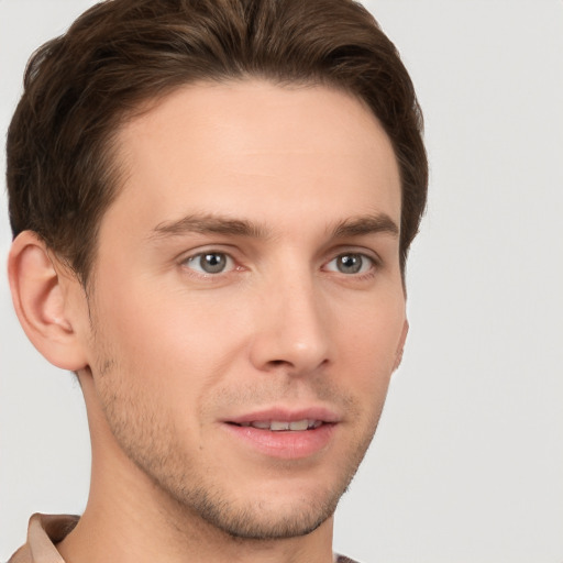 Joyful white young-adult male with short  brown hair and grey eyes