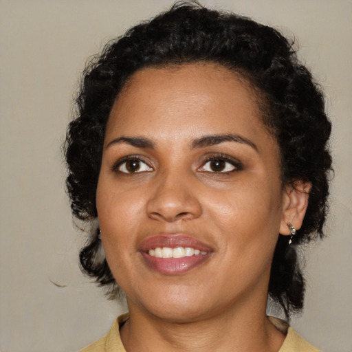 Joyful black young-adult female with medium  black hair and brown eyes