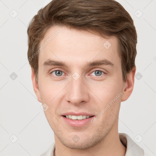 Joyful white young-adult male with short  brown hair and grey eyes