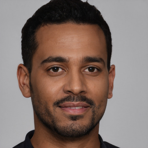 Joyful latino young-adult male with short  black hair and brown eyes