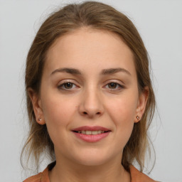 Joyful white young-adult female with medium  brown hair and grey eyes