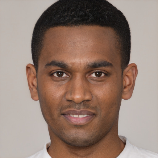 Joyful black young-adult male with short  black hair and brown eyes