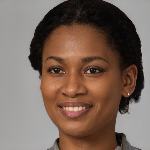 Joyful black young-adult female with short  black hair and brown eyes