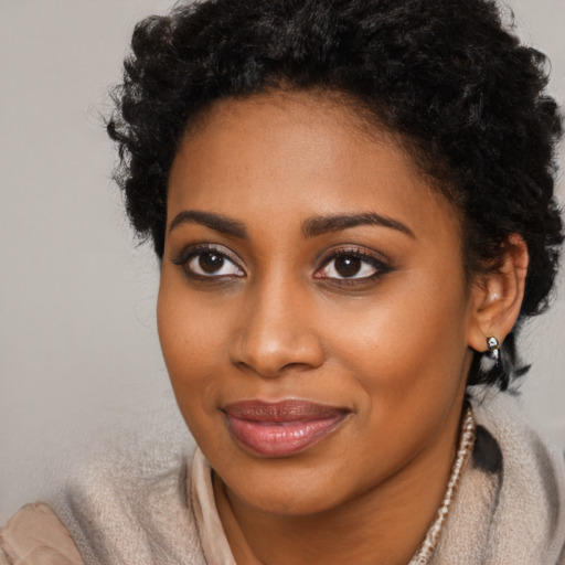 Joyful black young-adult female with short  brown hair and brown eyes