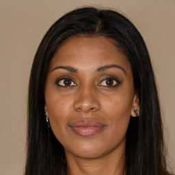 Joyful black young-adult female with long  brown hair and brown eyes