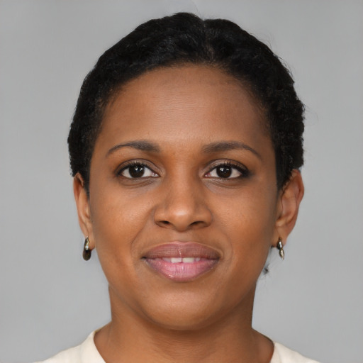 Joyful black young-adult female with short  brown hair and brown eyes