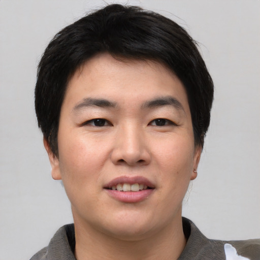 Joyful asian young-adult male with short  black hair and brown eyes