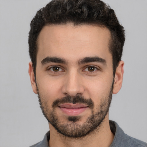 Joyful white young-adult male with short  black hair and brown eyes