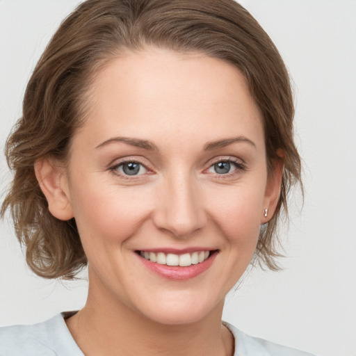 Joyful white young-adult female with medium  brown hair and grey eyes