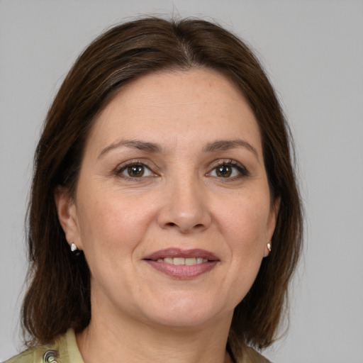 Joyful white adult female with medium  brown hair and grey eyes