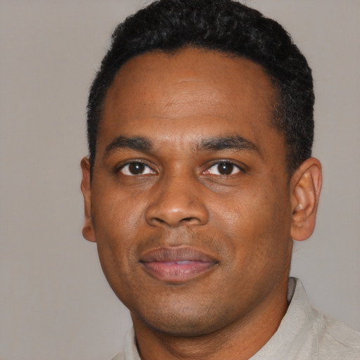 Joyful black young-adult male with short  black hair and brown eyes