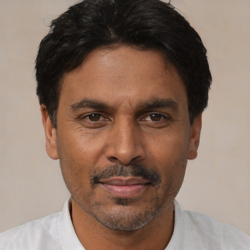 Joyful latino adult male with short  black hair and brown eyes