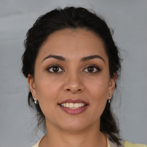 Joyful latino young-adult female with medium  brown hair and brown eyes