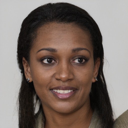 Joyful black young-adult female with long  black hair and brown eyes