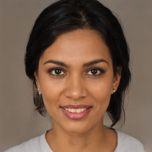 Joyful black young-adult female with medium  black hair and brown eyes
