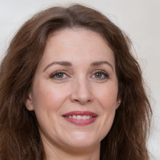 Joyful white adult female with long  brown hair and brown eyes