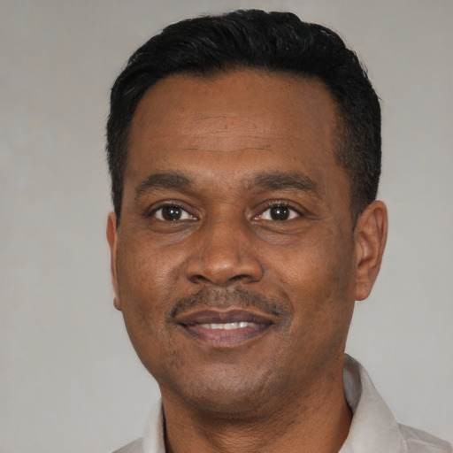 Joyful black young-adult male with short  black hair and brown eyes