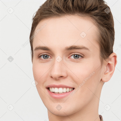 Joyful white young-adult female with short  brown hair and grey eyes