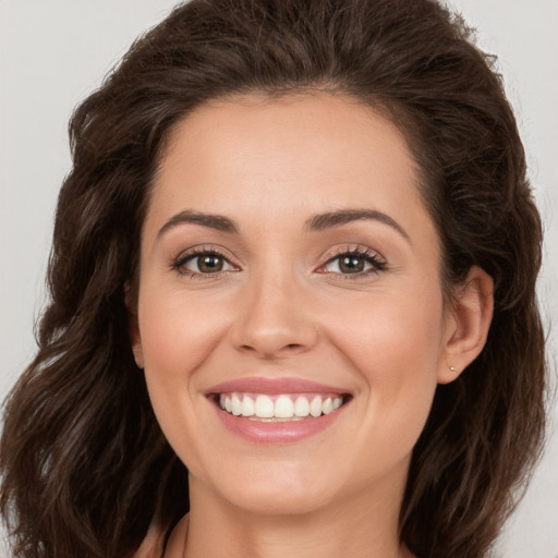 Joyful white young-adult female with long  brown hair and brown eyes