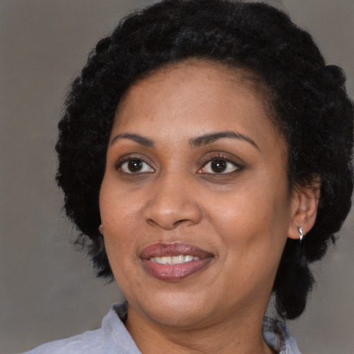 Joyful black adult female with medium  black hair and brown eyes