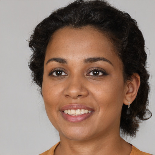 Joyful black young-adult female with medium  brown hair and brown eyes
