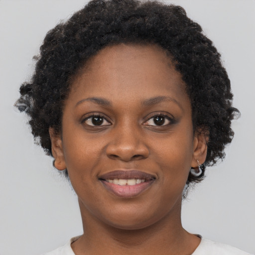 Joyful black young-adult female with short  brown hair and brown eyes