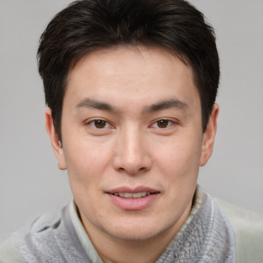 Joyful asian young-adult male with short  brown hair and brown eyes