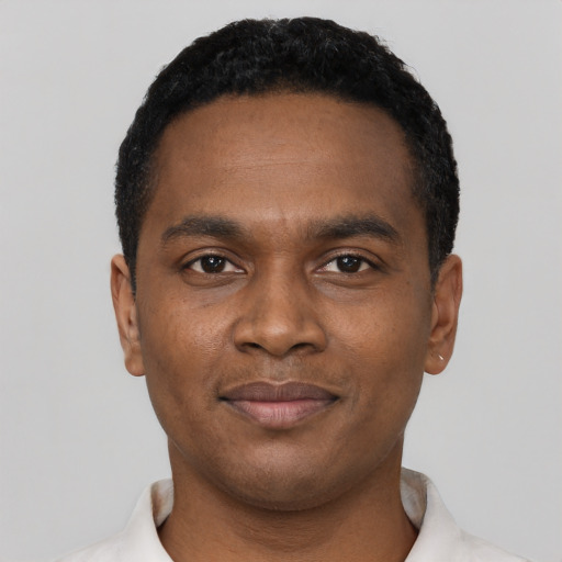 Joyful black young-adult male with short  black hair and brown eyes