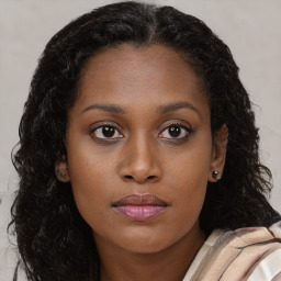 Joyful black young-adult female with long  brown hair and brown eyes