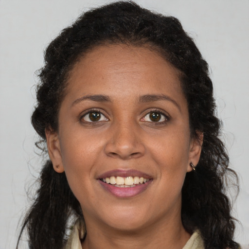 Joyful black young-adult female with long  brown hair and brown eyes