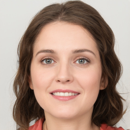 Joyful white young-adult female with long  brown hair and green eyes