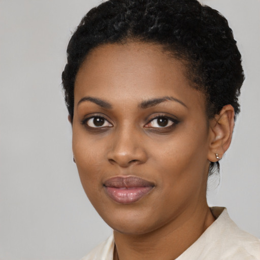 Joyful black young-adult female with short  black hair and brown eyes