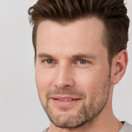 Joyful white adult male with short  brown hair and brown eyes