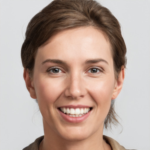 Joyful white young-adult female with medium  brown hair and grey eyes