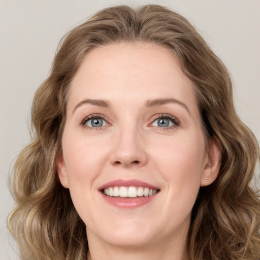 Joyful white young-adult female with medium  brown hair and green eyes