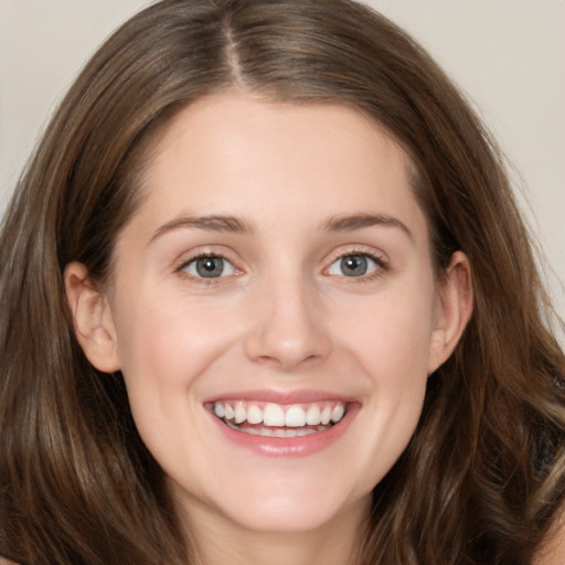 Joyful white young-adult female with long  brown hair and grey eyes